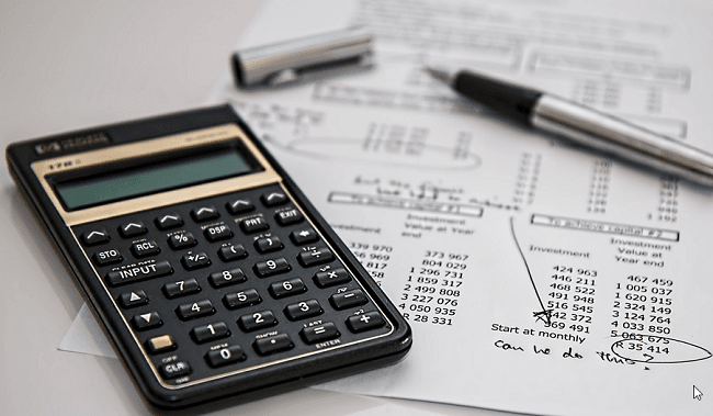 une calculatrice et un stylo, avec une feuille de calcul fiscal