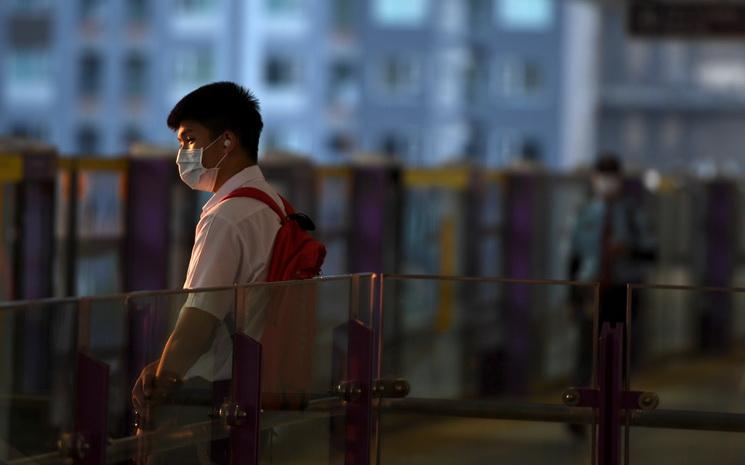 Un Thailandais portant un masque attend le metro durant la crise du Covid-19