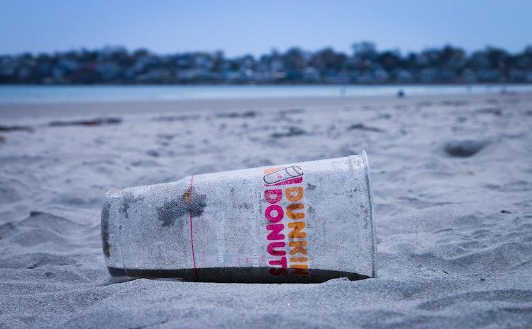 Un gobelet en plastique abandonné sur une plage