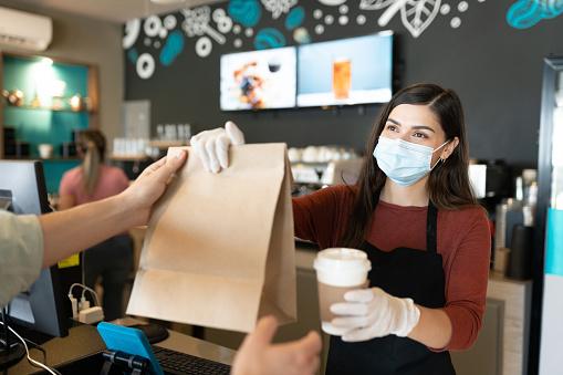 Une serveuse sert en Vente à emporter pendant la période de Covid-19