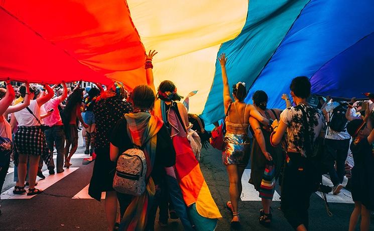 des personnes en dessous du drapeau lgbtq +-1