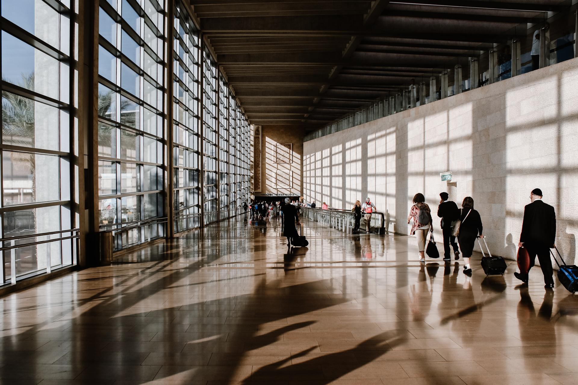 Des passagers avec leur valise marchent dans un aéroport