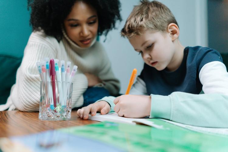 Une nourrice aidant un enfant à faire ses devoirs