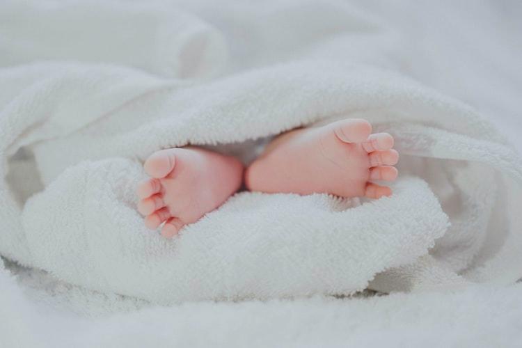 Les pieds d'un bébé dépassant d'une couette