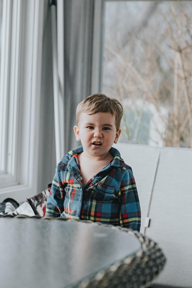 Un enfant regarde l'objectif, contrarié