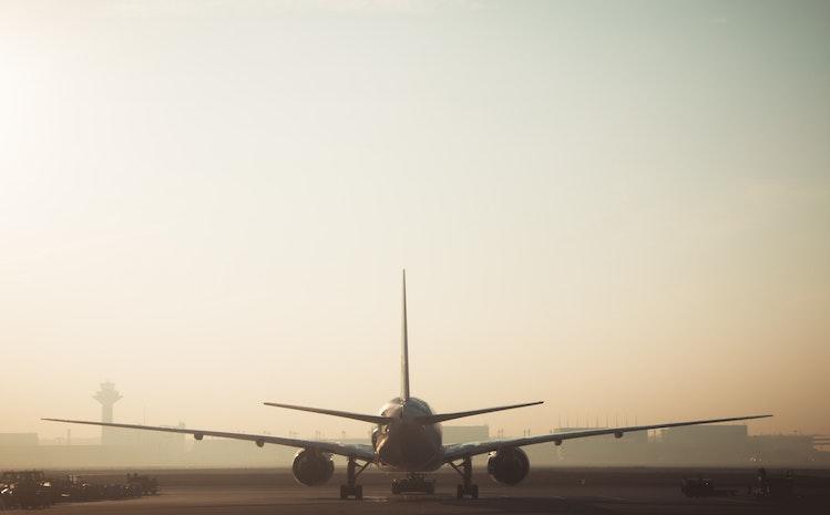 Un avion atterrissant au soleil couchant 