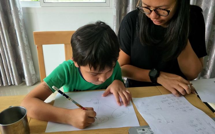 Enfant en Thailande qui fait l'école à la maison