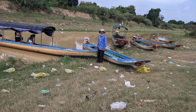 des villageois cambodgiens prés d'un bateau sur les rives du lac