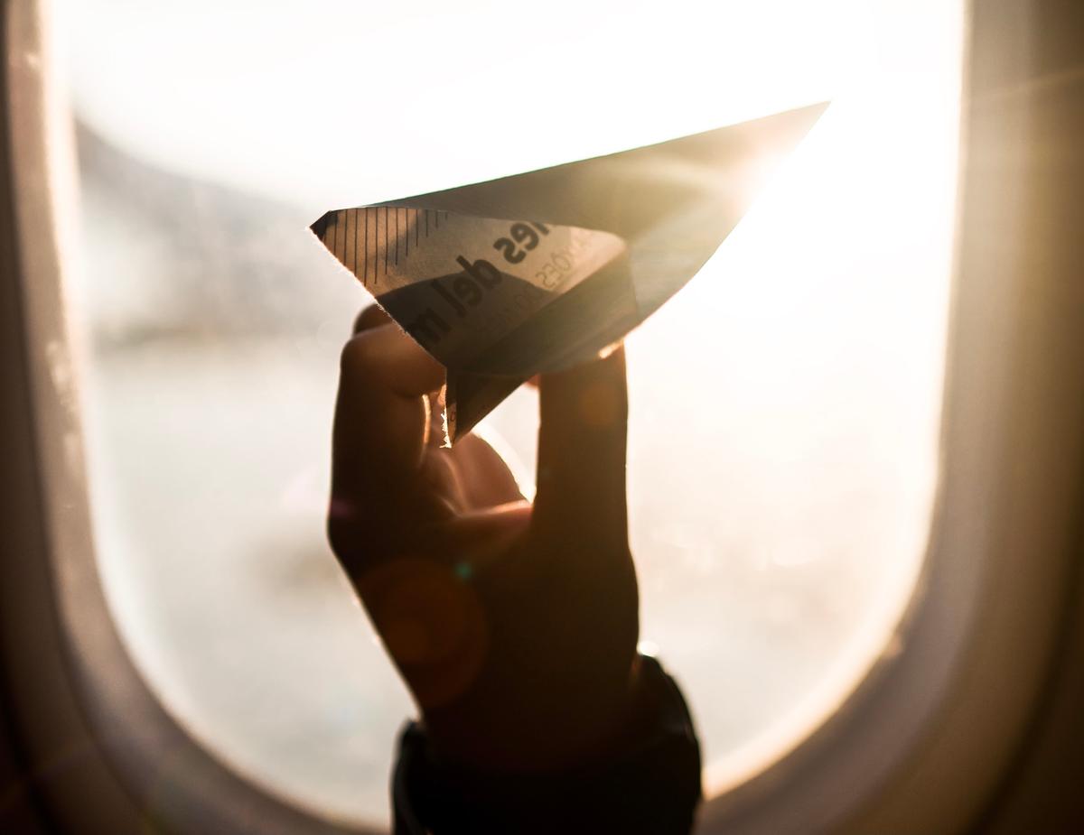 Un enfant tient un avion en papier 