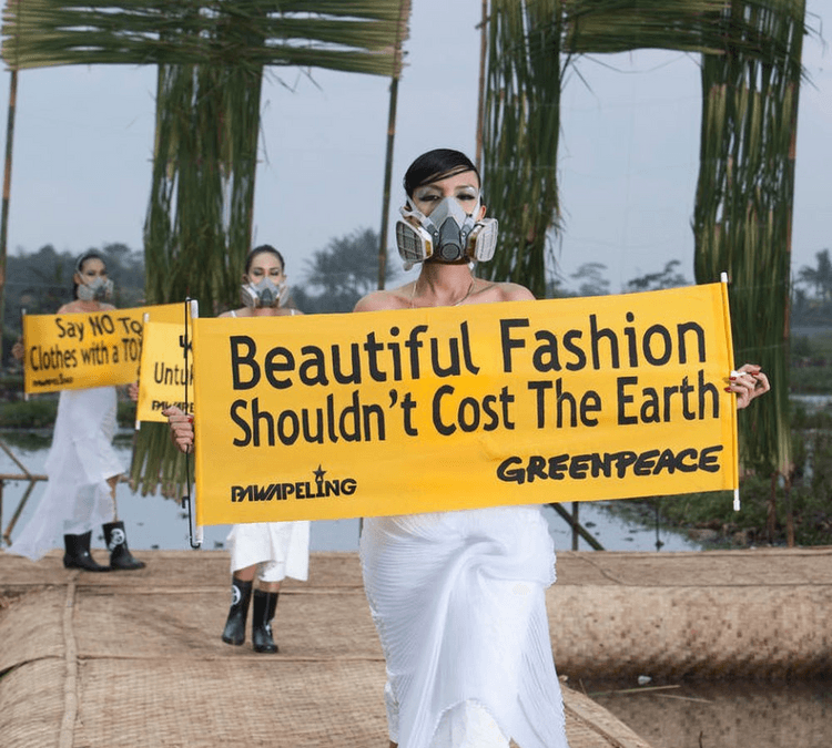 Un défilé de mode avec des pancartes avec messages pour l'environnement