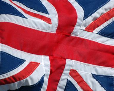 union jack et mains portant des doses de vaccin