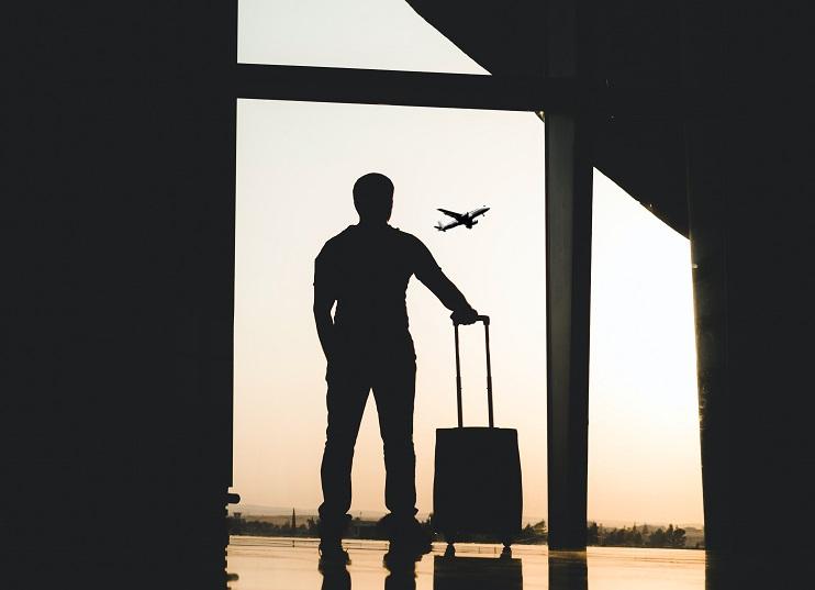 un voyageur avec sa valise, dans un aéroport