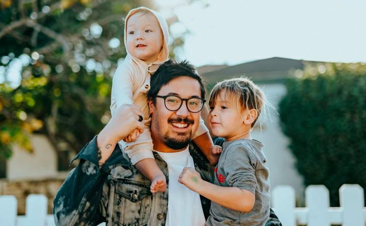 un père et ses enfants devant leur nouvelle maison