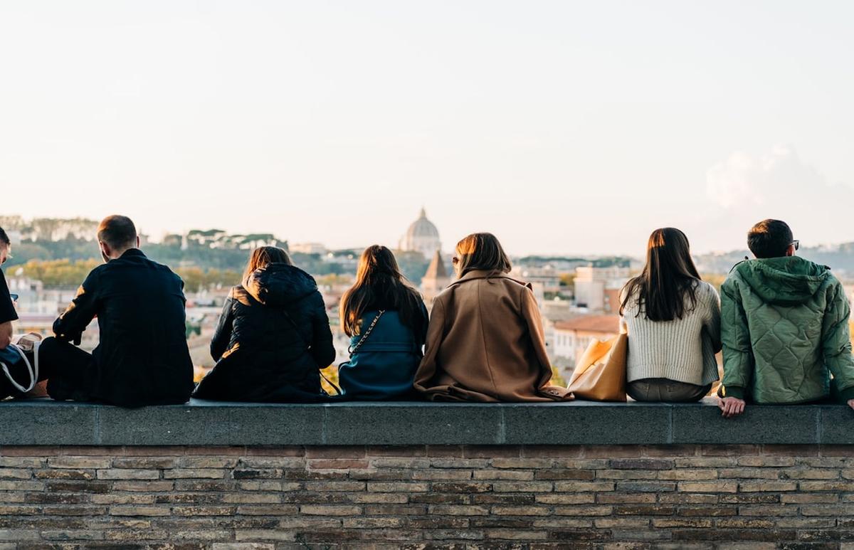 Des trentenaires assis sur un muret à Rome