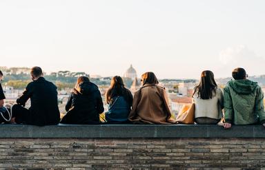 Des trentenaires assis sur un muret à Rome