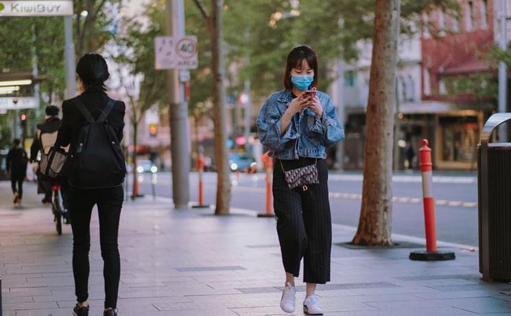 Une jeune femme masquée dans les rues d'Auckland