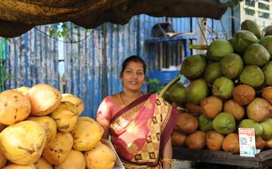 Chitra devant son stand de noix coco à Chennai