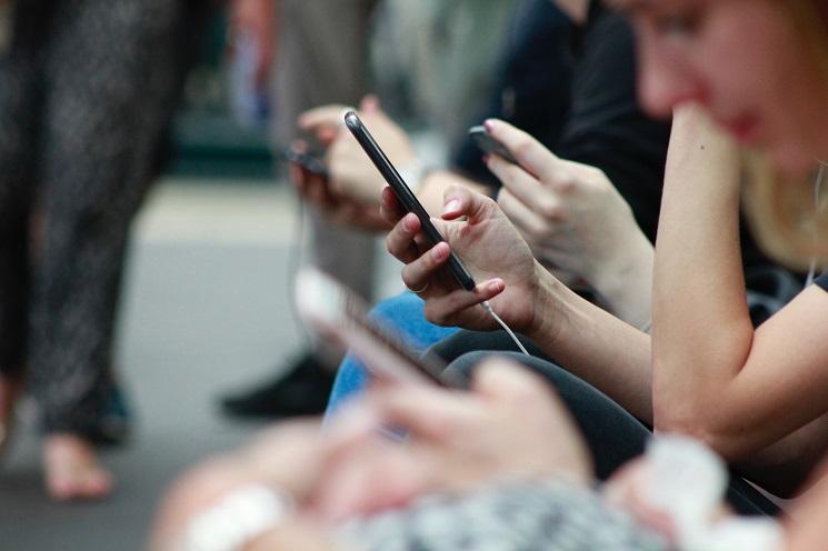 des personnes consultent leur téléphone dans le métro en Espagne