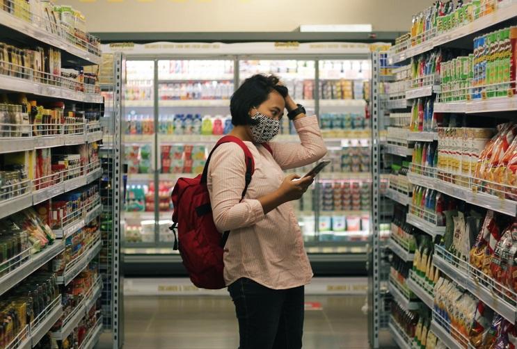 Une cliente regarde les articles dans les rayons du supermarché