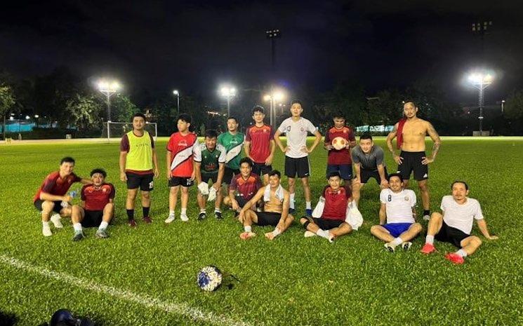 Une équipe de foot amateur à hong kong pose dans un stade la nuit 