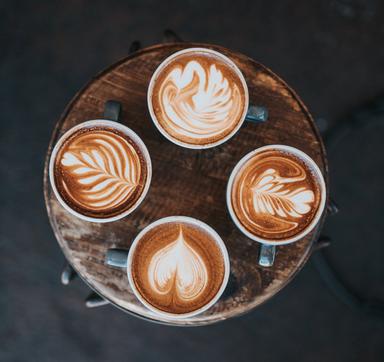 Quatre cafés latte sont posés sur une table 