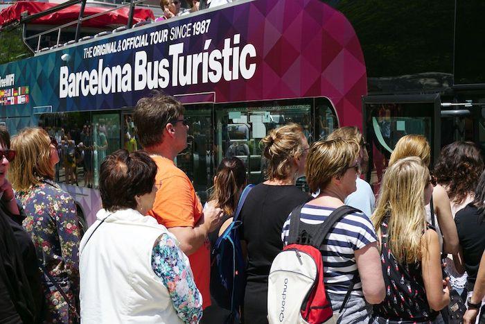 Des touristes rentrent dans un bus touristique de barcelone