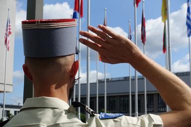 Salut militaire devant les drapeaux de l'OTAN - Photographe : Bénédicte Mezeix