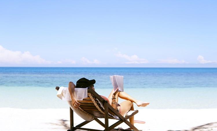 lire un livre sur un transat sur la plage