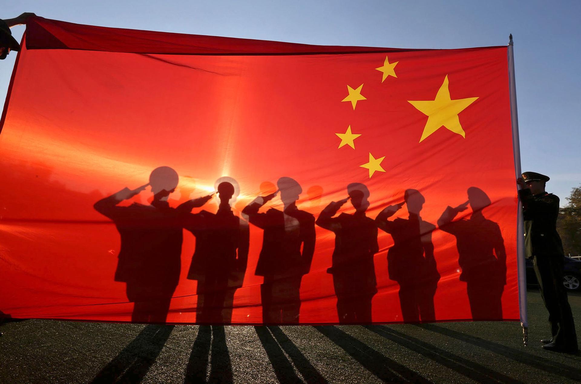 des militaires derrière un drapeau chinois