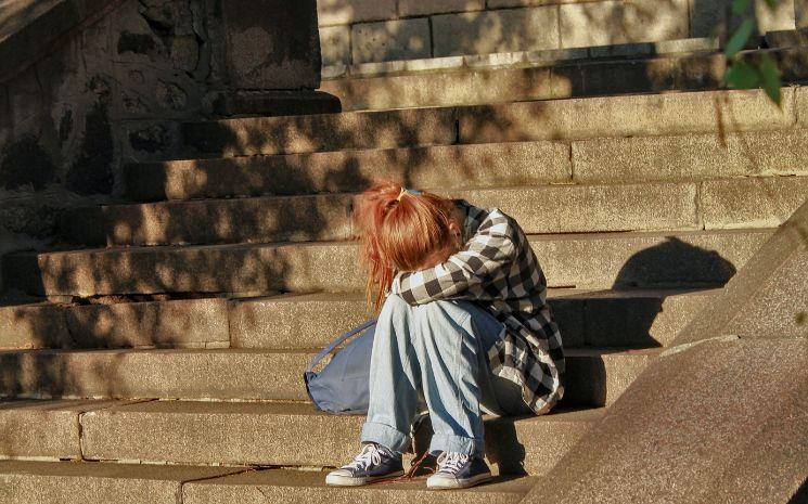 Une jeune fille est harcelée à l'école et pleure sur les escaliers 