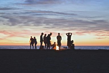 Les voyageurs regardent un coucher de soleil sur une plage 