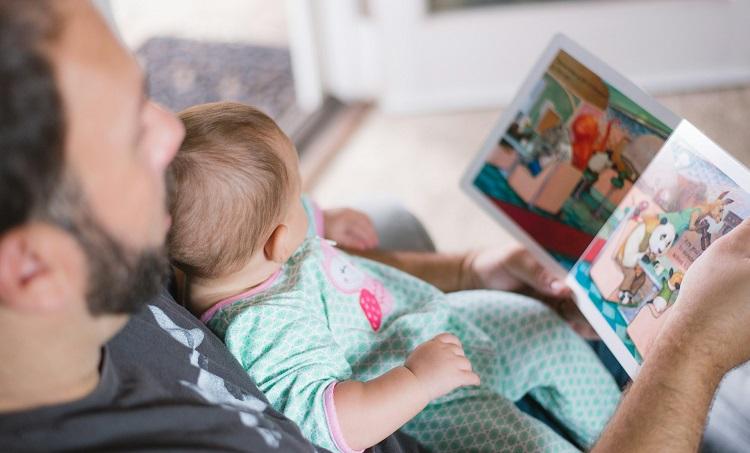 un papa lit un livre avec son bébé