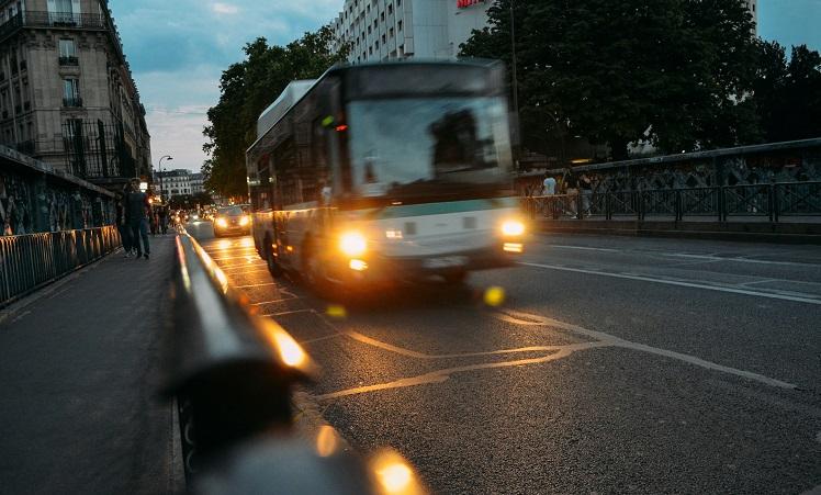 bus avec phares allumés à paris la nuit