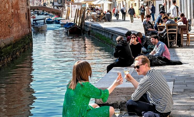 des gens prennent l'apéritif le long du canal de venise