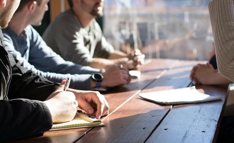 des personnes prennent des notes autour d'une table de travail - Copie