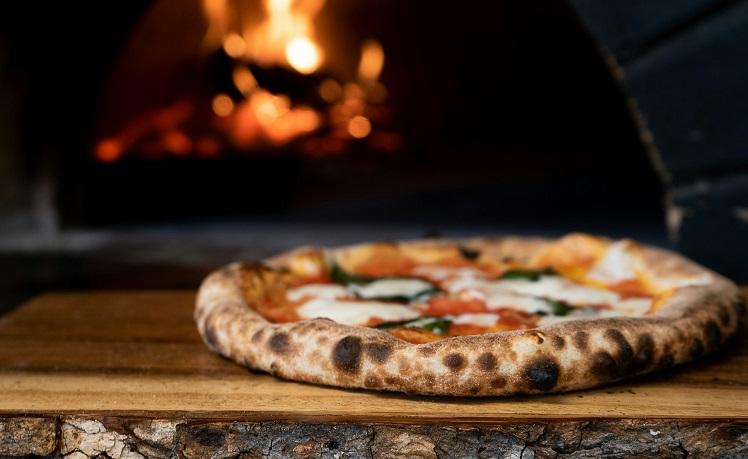 pizza italienne qui sort du four à feu de bois