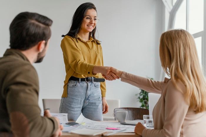 Femmes d'affaires se serrant la main au travail