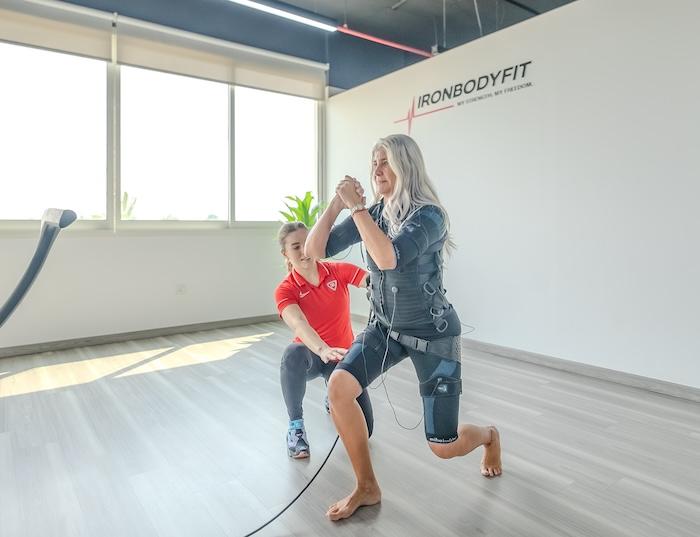 Une femme en train de faire une séance d'électro stimulation à valencia avec sa coach IronBodyfit