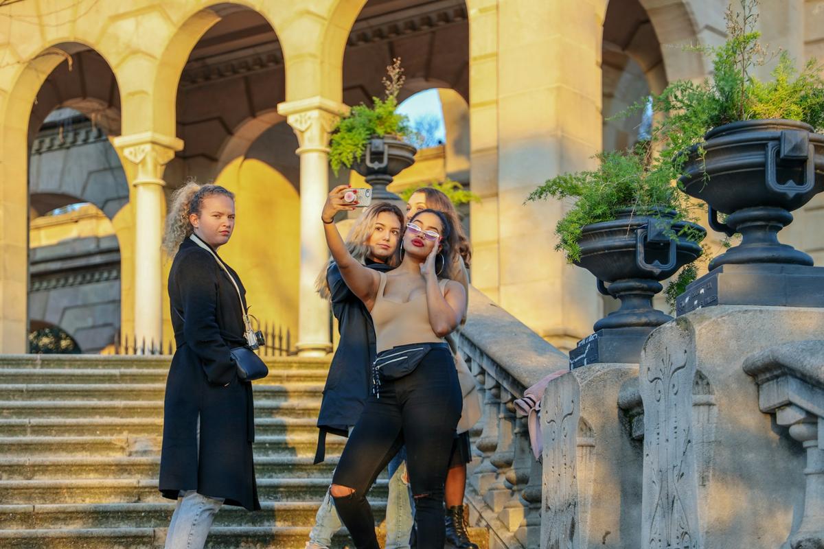 Un groupe de jeunes femmes prenant un selfie sur les marches d'un monument historique a barcelone