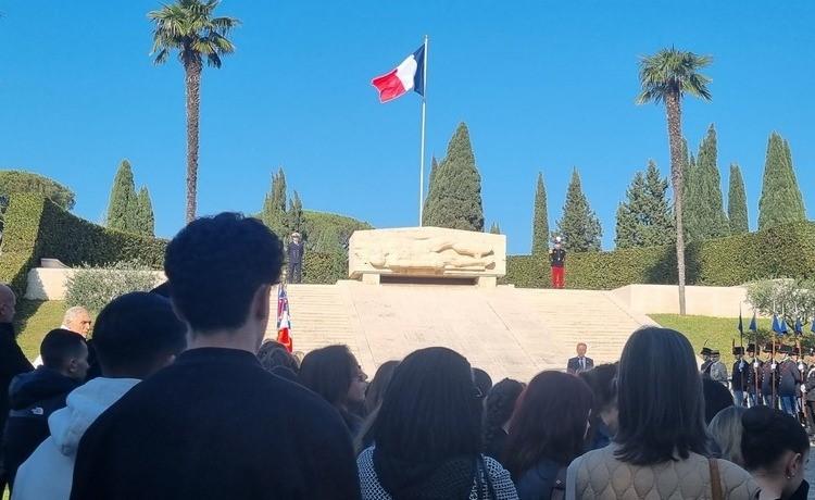 des personnes devant le drapeau français dans un cimetière à rome