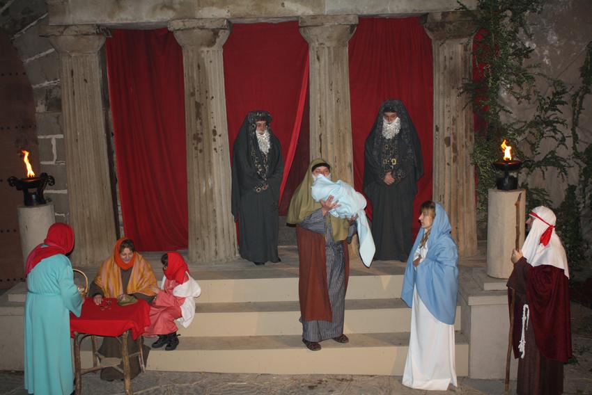 une scène d'une crèche vivante traditionnelle avec des personnages costumés dans un décor ancien