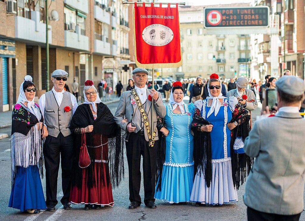 Un groupe de personnes portant les costumes traditionnels madrilènes, posant dans une rue de la ville