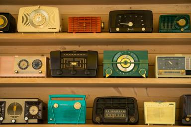 radios de différentes couleurs exposées sur un mur en bois