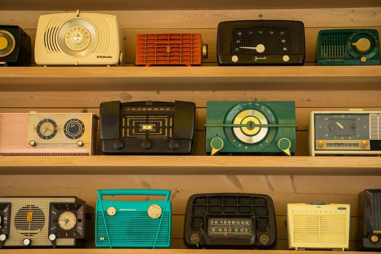 radios de différentes couleurs exposées sur un mur en bois