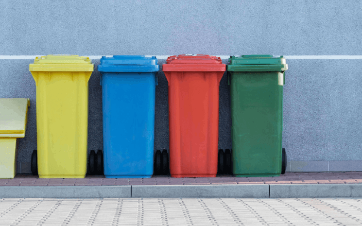 photo de 4 poubelles colorées alignées dans une rue