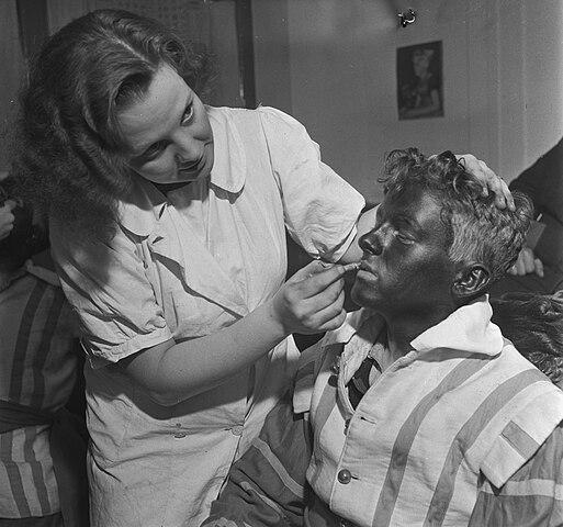 Homme se faisant peindre le visage en noir pour se déguiser en Zwarte Piet en 1945 