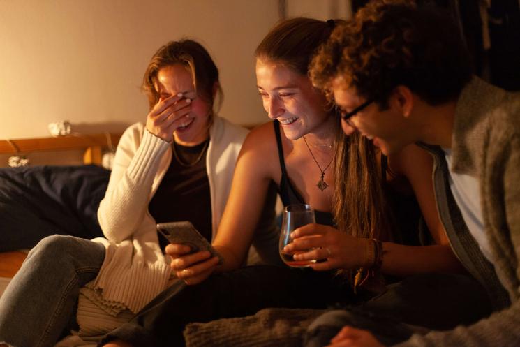 Photo d'amis en train de rigoler autour d'un téléphone