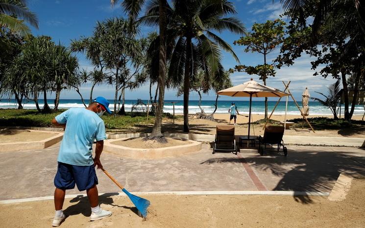 Un balayeur prepare la plage de Patong a Phuket pour l'arrivee des premiers touristes etrangers vaccines