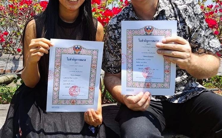 Un couple franco-thailandais montre ses certificats de mariage