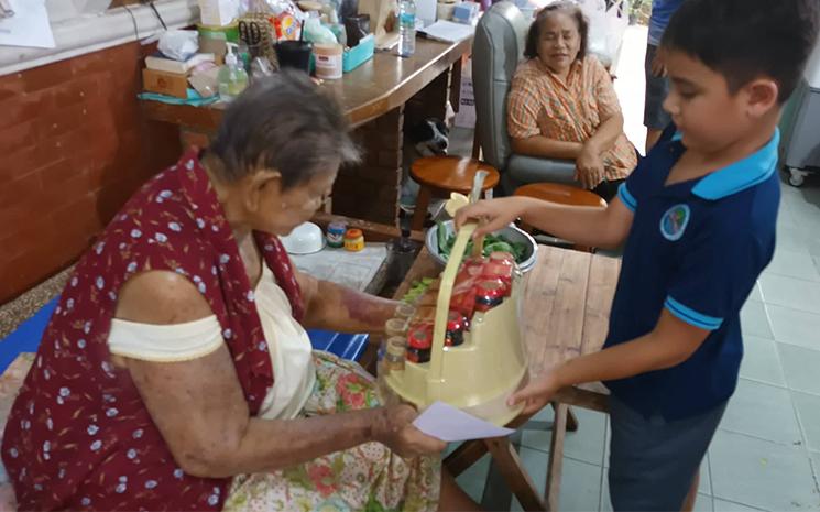 Un enfant thaïlandais offre un coffret de boissons fortifiantes à sa grand-mère le jour de la fête des mères